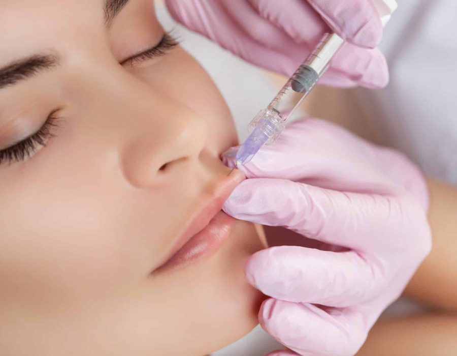 The doctor cosmetologist makes Lip augmentation procedure of a beautiful woman in a beauty salon.Cosmetology skin care.